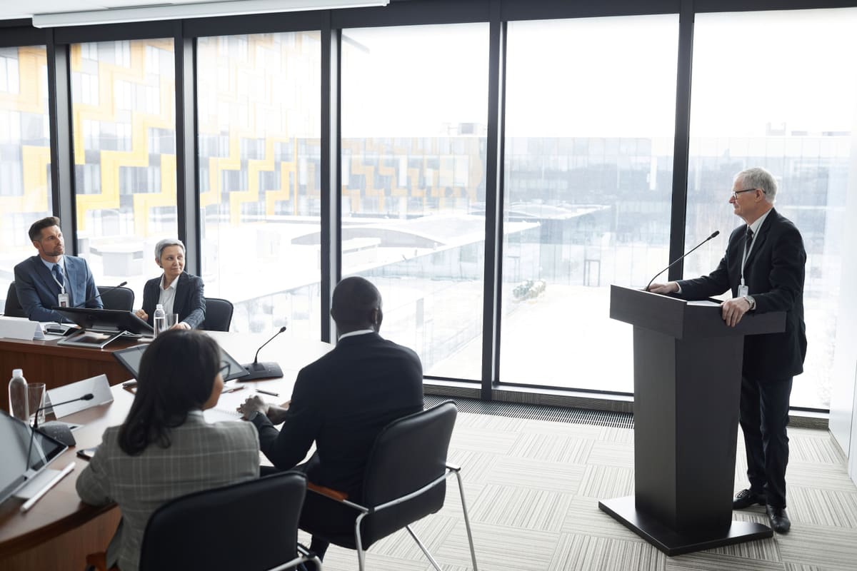 An executive briefing a boardroom from a podium