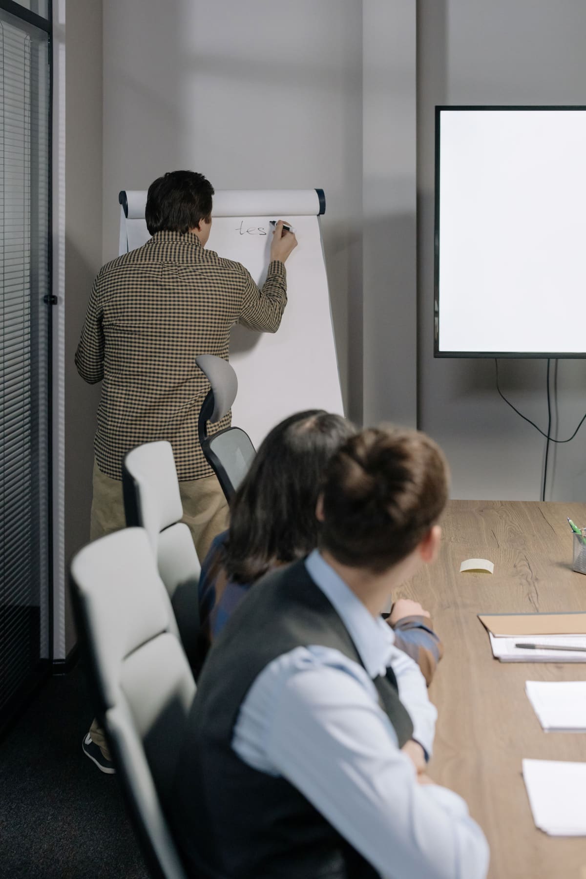 A facilitator writing notes on a flipchart during a briefing
